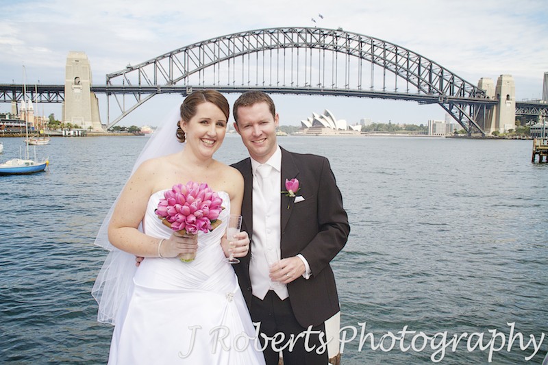 Bride and groom sipping champagne on Sydney harbour - wedding photography sydney